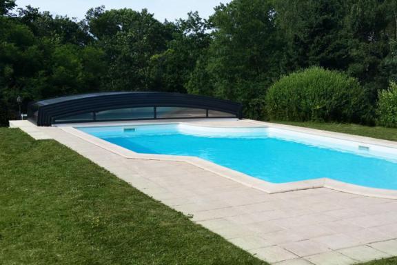 abri de piscine bas néo XXL ouvert sur la piscine