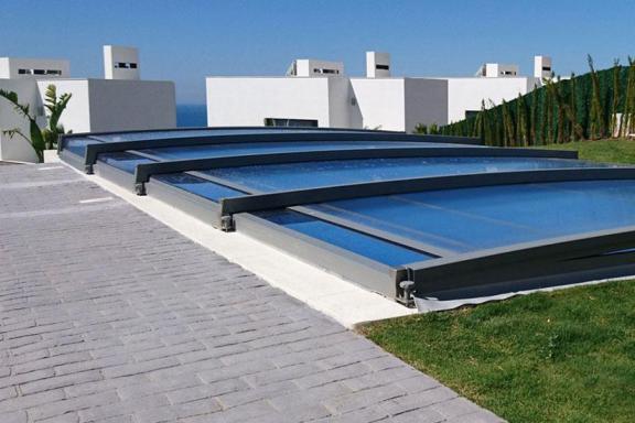abri de piscine néosmart plié très discret sur la piscine