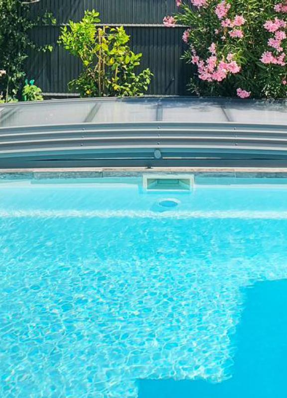 abri de piscine néosmart replié et ouvert sur la piscine